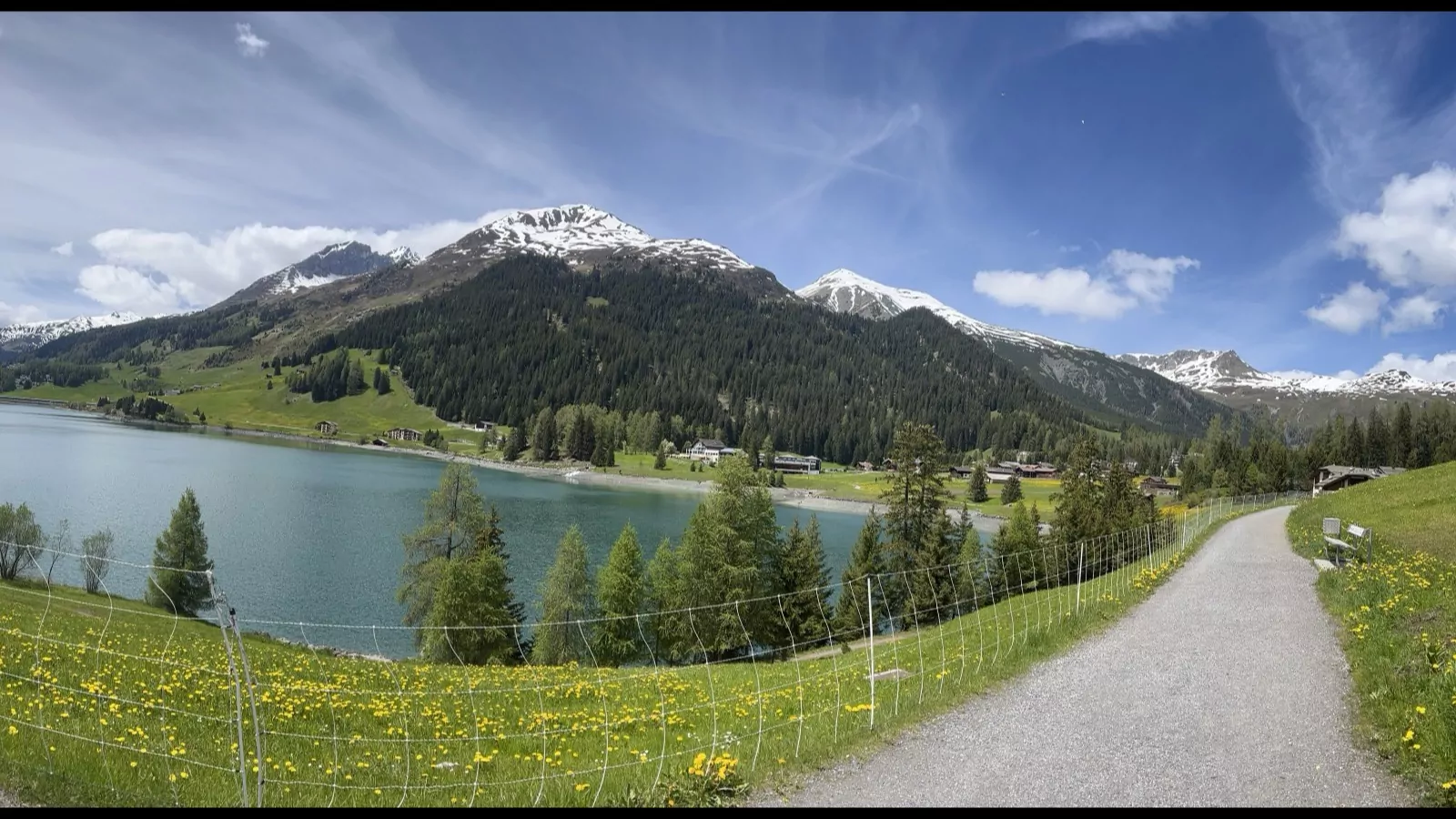 Uferweg am Davosersee im Frühsommer mit Blick über den See auf die Bergkette